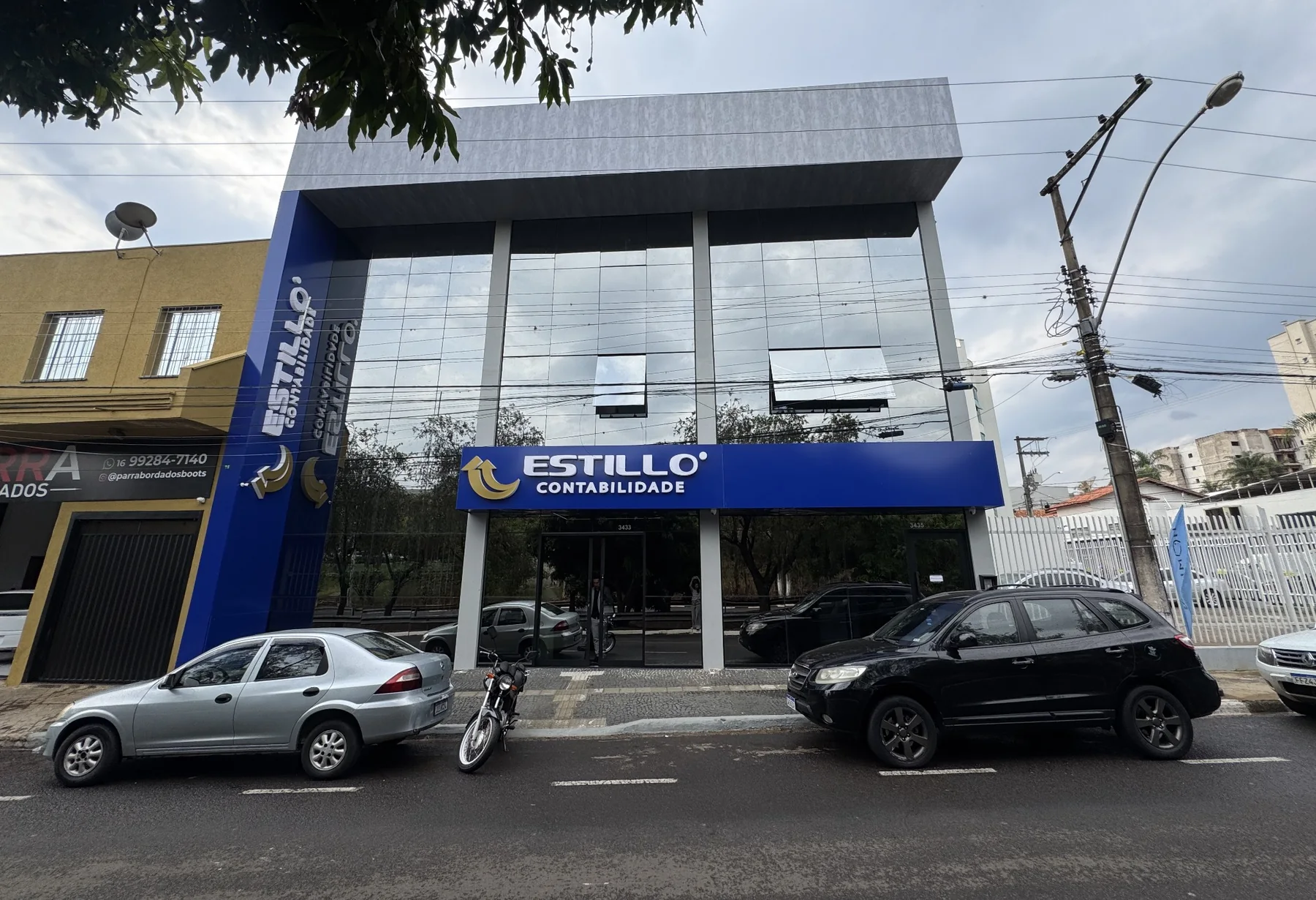 Fachada da Estillo Contabilidade com plano de vidro, volumes cinza e identidade azul